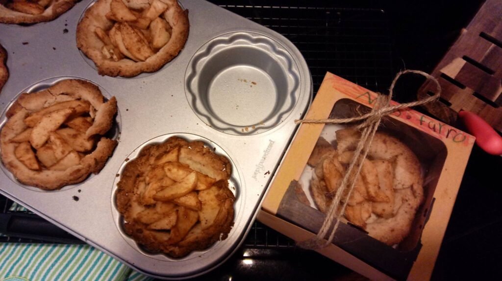 Freshly baked apple pies, one in a tin and one boxed for gifting. MettaWings gratitude for sharing homemade treats.