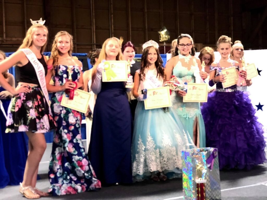 Junior Miss Fonda Fair winner with bouquet and sash on stage