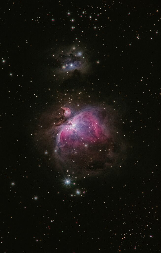 A vibrant image of a galaxy with clusters of stars and nebulous regions in shades of blue and pink against the dark backdrop of space. A stunning example of upcoming celestial events.