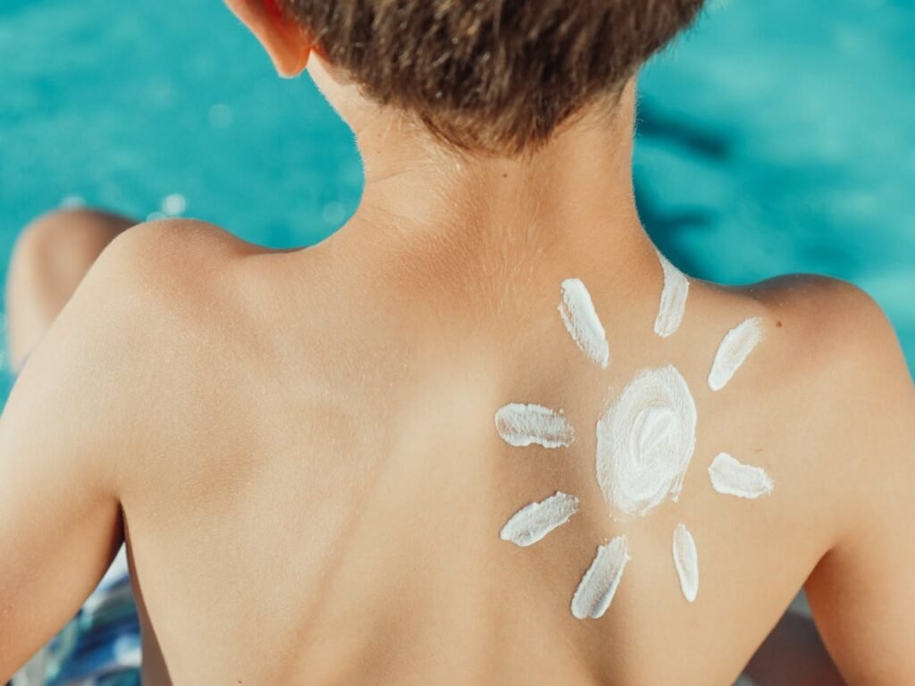 A child’s back with a sun-shaped sunscreen application. Labor Day travel tips