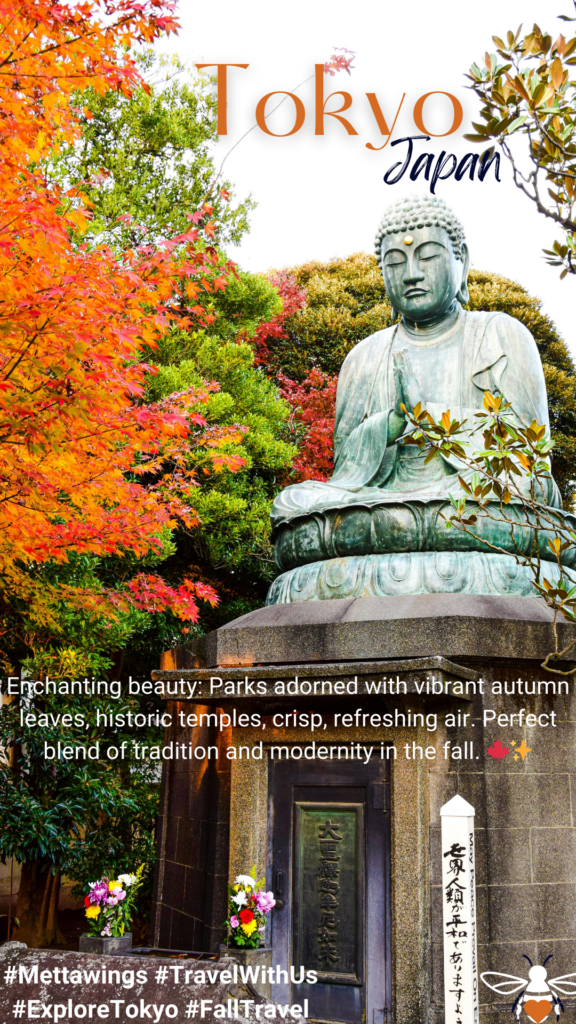 A large bronze Buddha statue sits serenely amidst vibrant autumn foliage in Tokyo, with a stone pedestal and offerings at its base.