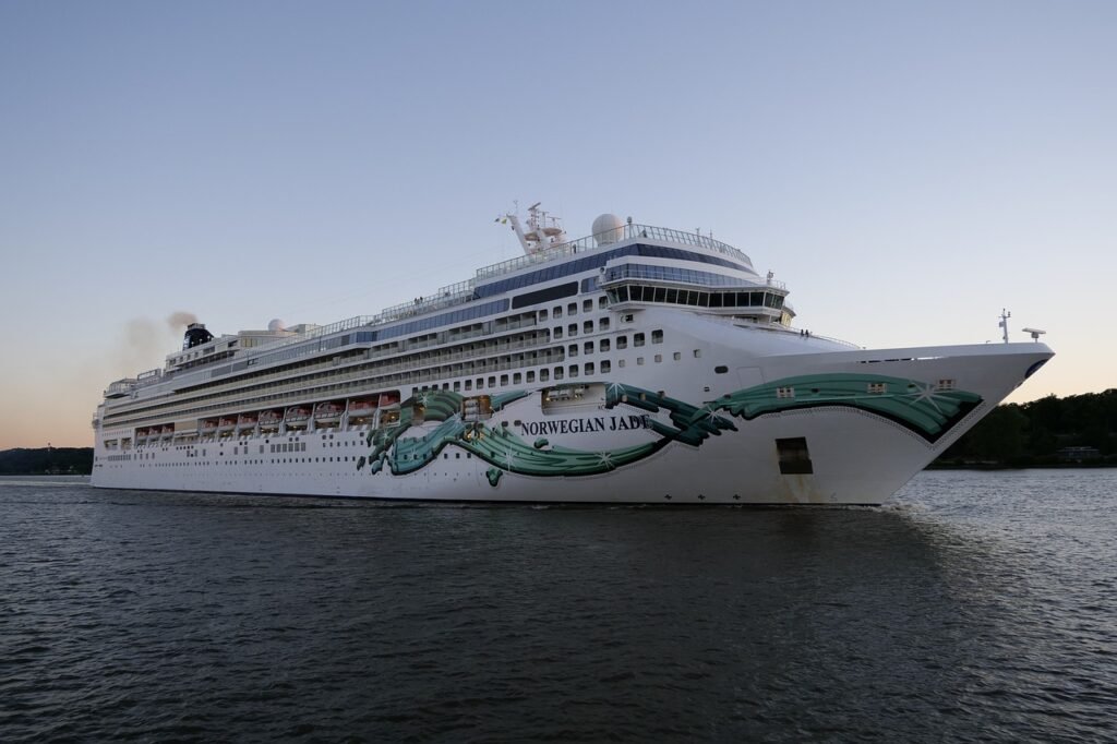 Cruise ship ‘NORWEGIAN JADE’ floating on calm waters at dusk with clear skies.