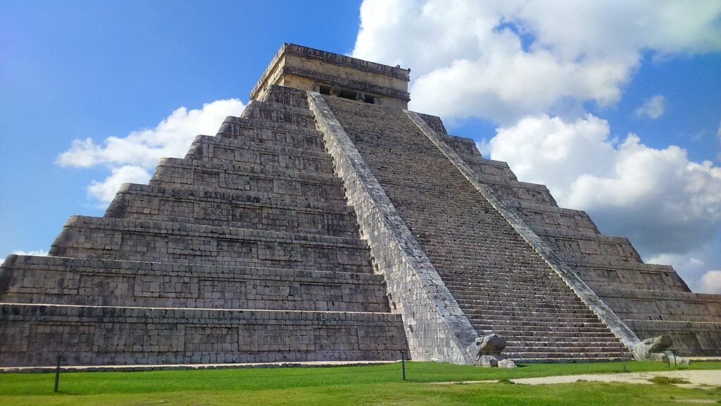 Image of the Kukulkan Pyramid at Chichen Itza under a clear blue sky.