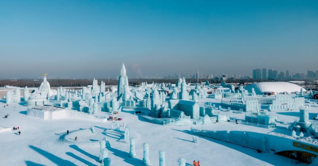 A panoramic view of the Harbin International Ice and Snow Sculpture Festival, showcasing an expansive array of intricate ice sculptures under a clear blue sky.