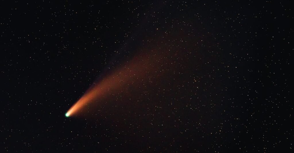 Bright comet with ion tail against starry night sky, part of October 2024 Celestial Events.