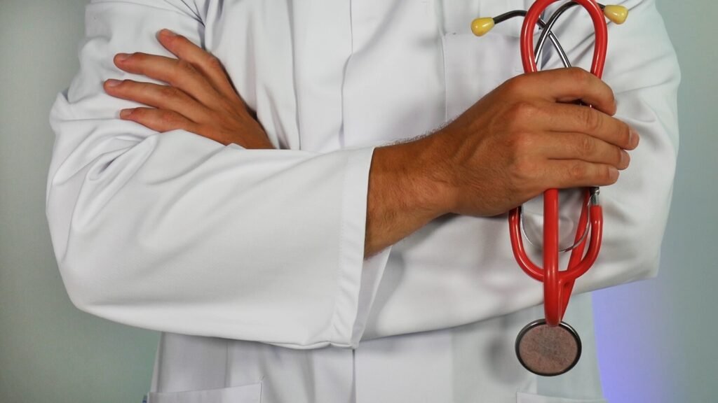 Doctor holding a red stethoscope with hands crossed, representing travel clinic services and medical expertise.